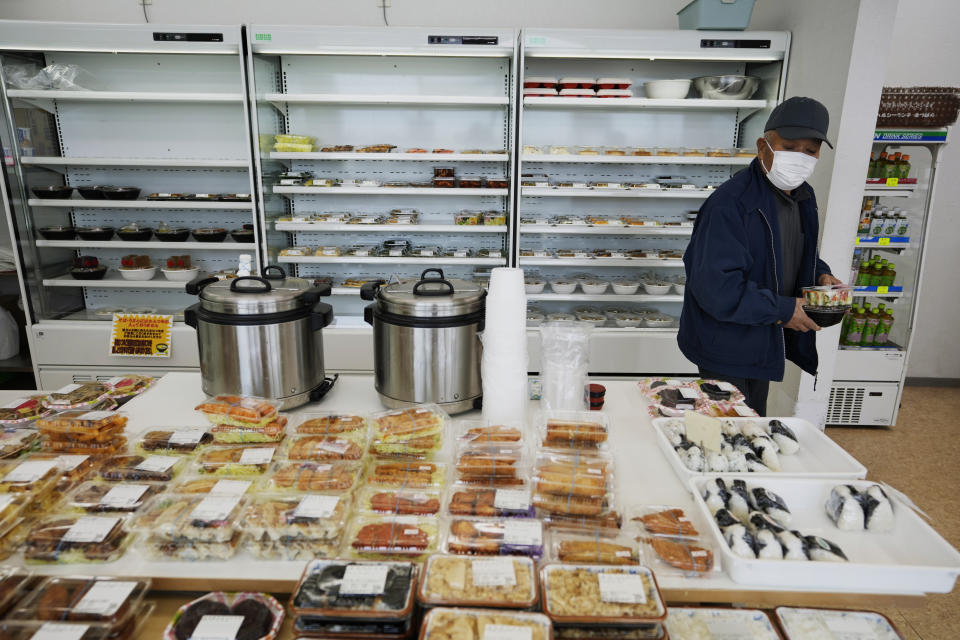 Yasushi Hosozawa makes a daily choir to buy his meal at a fast-food takeout shop in Namie town, northeastern Japan, Wednesday, March 2, 2022. Hosozawa returned on the first day possible after a small section of his hometown, Futaba, reopened in January — 11 years after the nuclear meltdown at the nearby Fukushima Daiichi plant. (AP Photo/Hiro Komae)