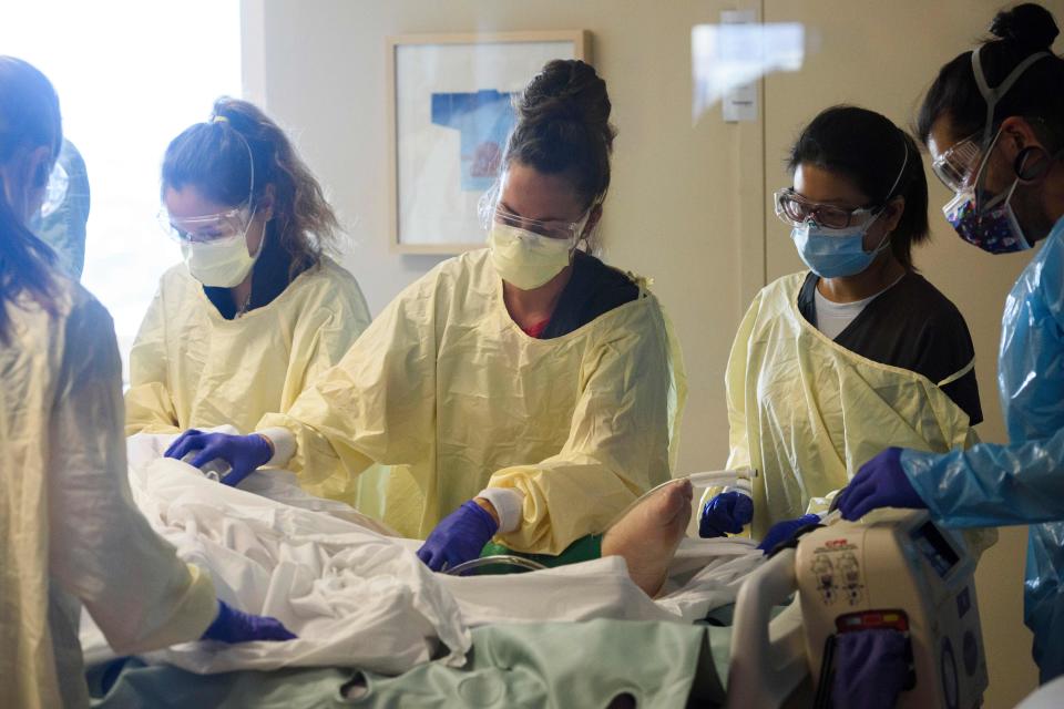 A team of health care workers including physicians, nurses, certified nursing assistants, and respiratory specialists wear personal protective equipment (PPE) after turning a patient from their stomach onto their back in the Covid-19 intensive care unit (ICU) at Renown Regional Medical Center on December 16, 2020 in Reno, Nevada. - Renown Health converted two floors of a parking garage into an alternative care site for Covid-19 patients to increase hospital capacity amid a surge in cases, allowing other facilities to be used for patients in more serious condition. The site included the addition of flooring, electrical infrastructure, lighting, water, technology, sanitation, and ventilation. President Trump earlier this month retweeted a tweet that described Renown&#39;s structure as 