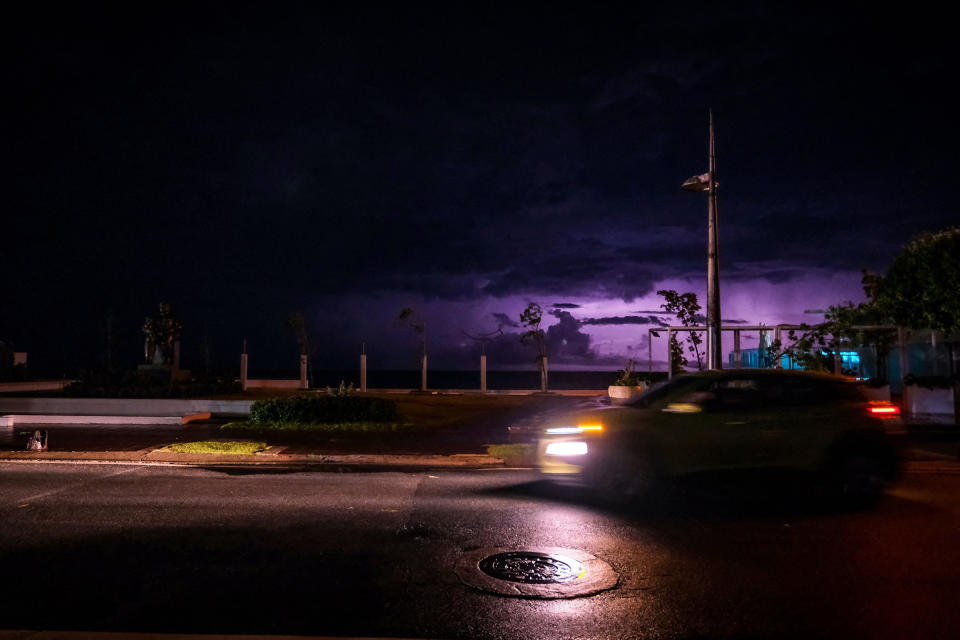 A car's headlights light an otherwise dark street in the Condado community of Santurce in San Juan, after the passage of Hurricane Fiona, Sept. 19.<span class="copyright">AFP/Getty Images</span>