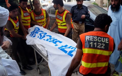 Rescue workers remove the body of Ikramullah Gandapur - Credit: AP