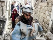 <p>SEPT. 25, 2017 – A search and rescue member holds a baby wrapped with a blanket after Assad Regime’s forces carried out air strikes over the de-conflict zone, at the Jisr al-Shughur district of Idlib, Syria. (Photo: Hadi Kharat/Anadolu Agency/Getty Images) </p>
