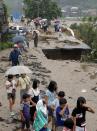 <p>People walk through a damaged road to flee from an isolated school in Asakura, Fukuoka prefecture, southwestern Japan Thursday, July 6, 2017. Troops were working Thursday to rescue families left stranded by flooding in southern Japan. Heavy rain warnings were in effect for much of the southern island of Kyushu after Typhoon Nanmadol swept across Japan earlier in the week. (Photo: Takuto Kaneko/Kyodo News via AP) </p>