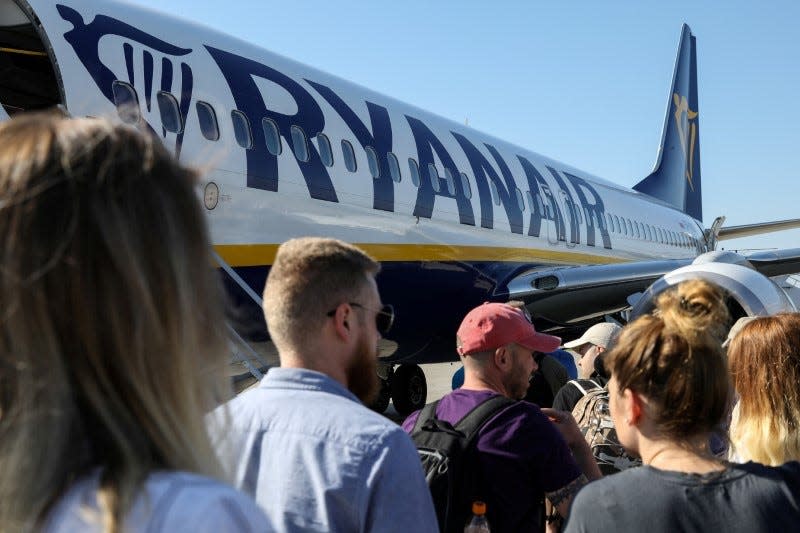 FILE PHOTO: Passengers board a Ryanair flight at the airport in Gdansk, Poland, June 19, 2019. REUTERS/Kevin Coombs/File Photo