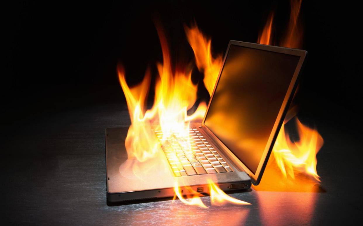 Laptop computer on fire - PM Images/Stone RF