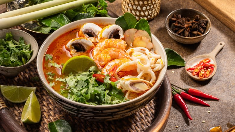 Tom Yum soup surrounded by ingredients 