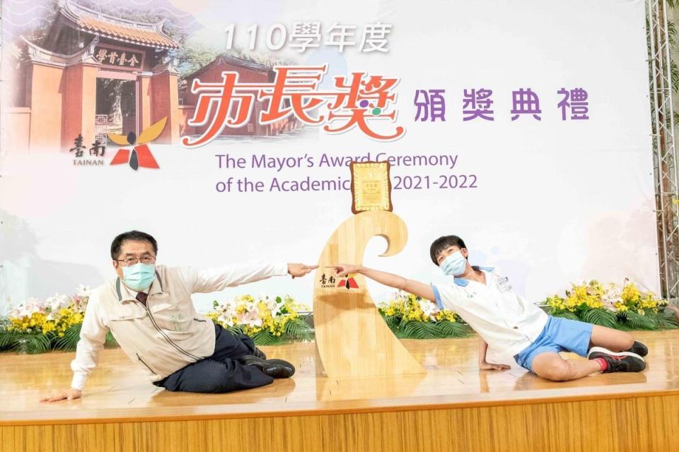 黃偉哲和學子合照，配合擺出名畫「創世紀」的姿勢，展現親和力。（台南市政府提供）