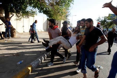 Anti-government protesters carry a man injured during the storming of Baghdad's Green Zone in Iraq May 20, 2016. REUTERS/Khalid al Mousily