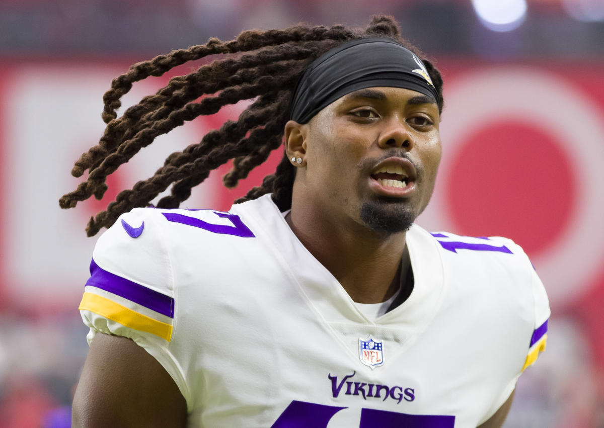 A Minnesota Vikings fan holds up a helmet with a pink ribbon on it as he  watches an NFL football game between the Vikings and the Kansas City Chiefs  Sunday, Oct. 2