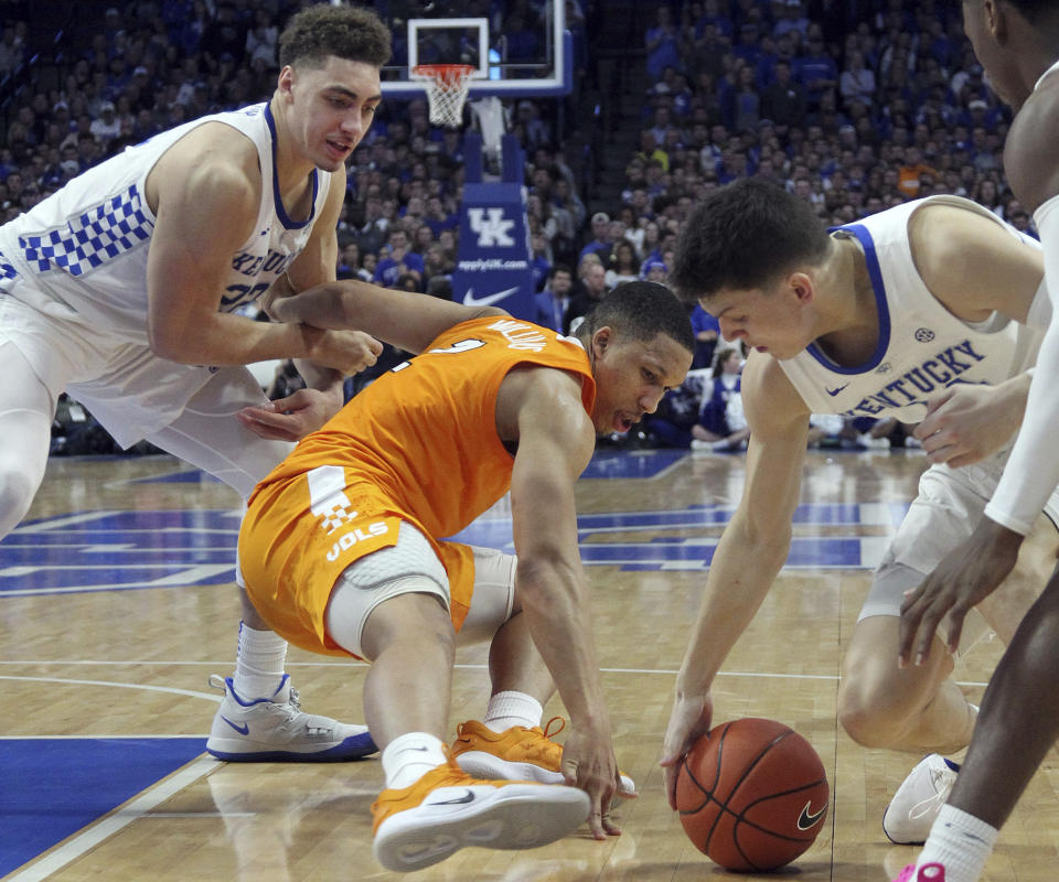 Tennessee's Grant Williams, middle, tries to pull in a loose ball between Kentucky's Reid Travis, left, and Tyler Herro during the second half of an NCAA college basketball game in Lexington, Ky., Saturday, Feb. 16, 2019. Kentucky won 86-69. (AP Photo/James Crisp)