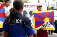 Tibetan monk Golog Jigme holds a Tibetan flag during protests outside the Beijing 2022 Winter Olympic Candidate City presentation at the Palace hotel in Lausanne, Switzerland in this June 10, 2015 file photo.REUTERS/Ruben Sprich/Files