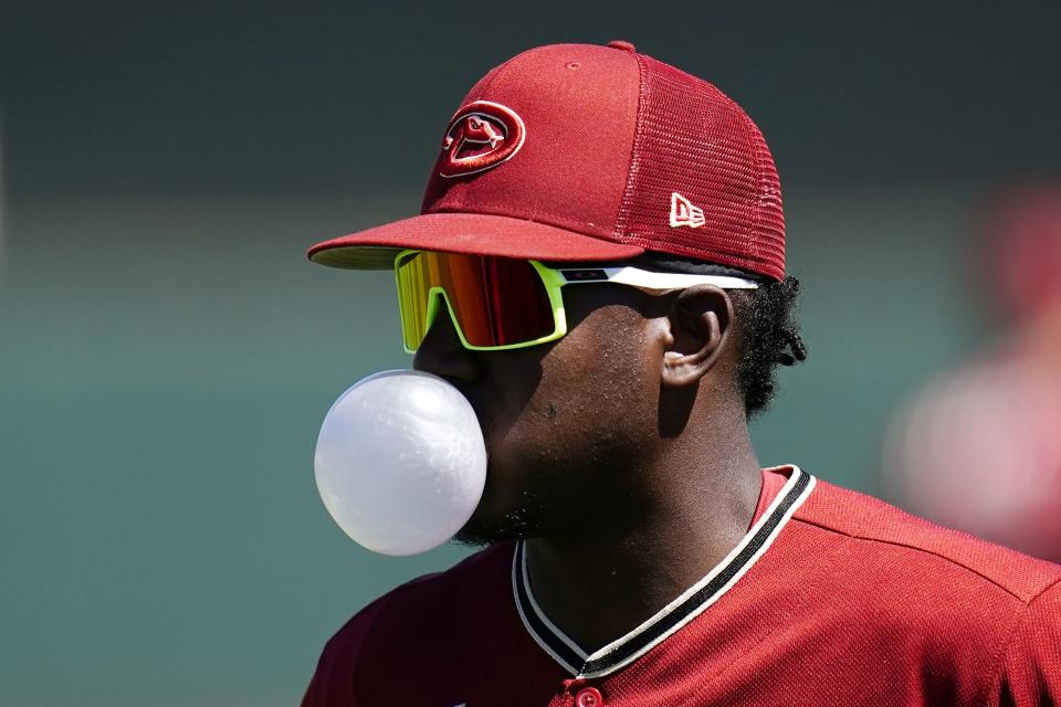 Arizona Diamondbacks' Geraldo Perdomo blows a bubble as he warms up prior to a spring training baseball game against the San Francisco Giants Wednesday, March 23, 2022, in Scottsdale, Ariz. (AP Photo/Ross D. Franklin)