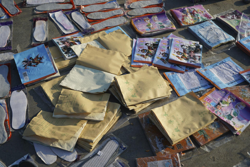 Piles of exercise books and shoe insoles dry in the sun near Yubei Agricultural and Aquatic Products World in Xinxiang in central China's Henan Province, Monday, July 26, 2021. Record rain in Xinxiang last week left the produce and seafood market soaked in water. Dozens of people died in the floods that immersed large swaths of central China's Henan province in water. (AP Photo/Dake Kang)