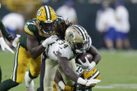 New Orleans Saints running back Tony Jones Jr. (34) carries against Green Bay Packers linebacker Quay Walker (7) during the first half of a preseason NFL football game Friday, Aug. 19, 2022, in Green Bay, Wis. (AP Photo/Matt Ludtke)