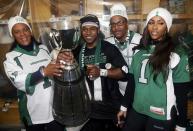 The Saskatchewan Roughriders Kory Sheets (2nd L) and his family pose with the Grey Cup in the dressing room after beating the Hamilton Tiger-Cats in the CFL's 101st Grey Cup championship football game in Regina, Saskatchewan November 24, 2013. REUTERS/Mark Blinch (CANADA - Tags: SPORT FOOTBALL)