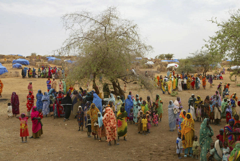 FILE - Sudanese displaced people gather at the Zam Zam refugee camp outside the town of El-Fashir in the Darfour region of Sudan, during a visit by U.N. officials, on July 1, 2004. The U.N. humanitarian aid and refugee agencies appealed Wednesday, Feb. 7, 2024, for $4.1 billion in international support for embattled civilians in Sudan amid signs that some may be dying of starvation after nearly a year of war there between the forces of rival generals. (AP Photo/Karel Prinsloo, File)