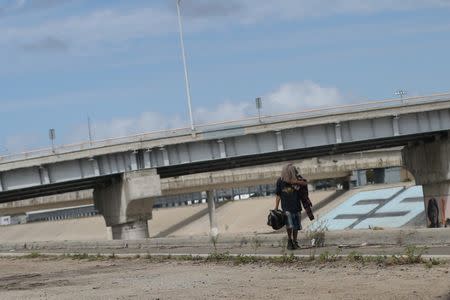 A Mexican who was recently deported from the U.S. walks by the Tijuana river, in Tijuana, Mexico, February 22, 2017. REUTERS/Edgard Garrido