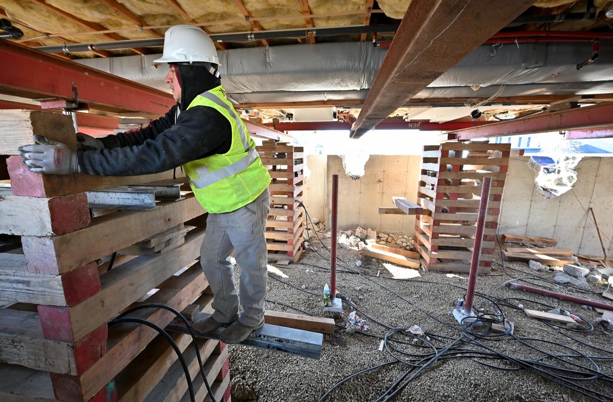 A worker works under 4 William Circle in Rutland as it is raised above its foundation due to the content of pyrrhotite, a mineral that causes foundation crumbling.