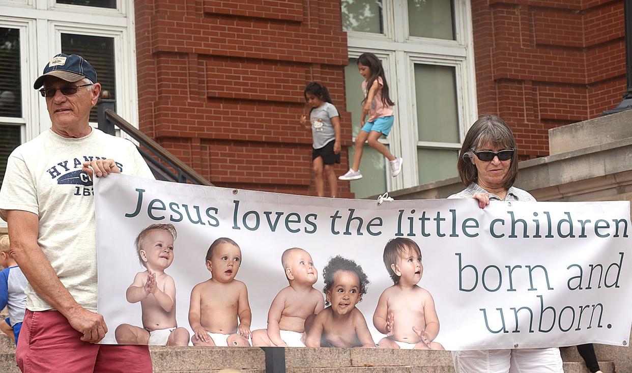 Dennis Fessler of Macon and Mary Hoffmeyer of Taos hold a sign in front of the Missouri Supreme Court in Jefferson City on Friday as about 80 people applauded the U.S. Supreme Court’s decision to overturn the 1973 landmark decision of Roe v. Wade that legalized abortion.