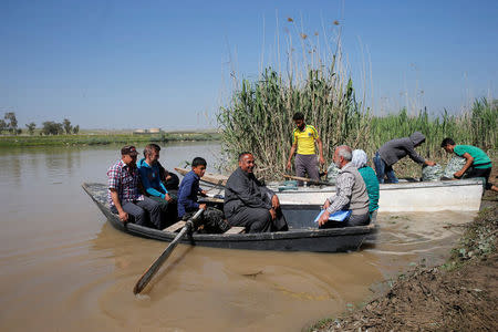 Displaced Iraqis from Mosul cross the Tigris by boat as flooding after days of rainfall has closed the city's bridges, at the village of Thibaniya, south of Mosul. REUTERS/Muhammad Hamed