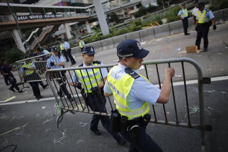 Police remove barricades erected by pro-democracy protesters at the main protest site in Admiralty in Hong Kong October 13, 2014. REUTERS/Carlos Barria