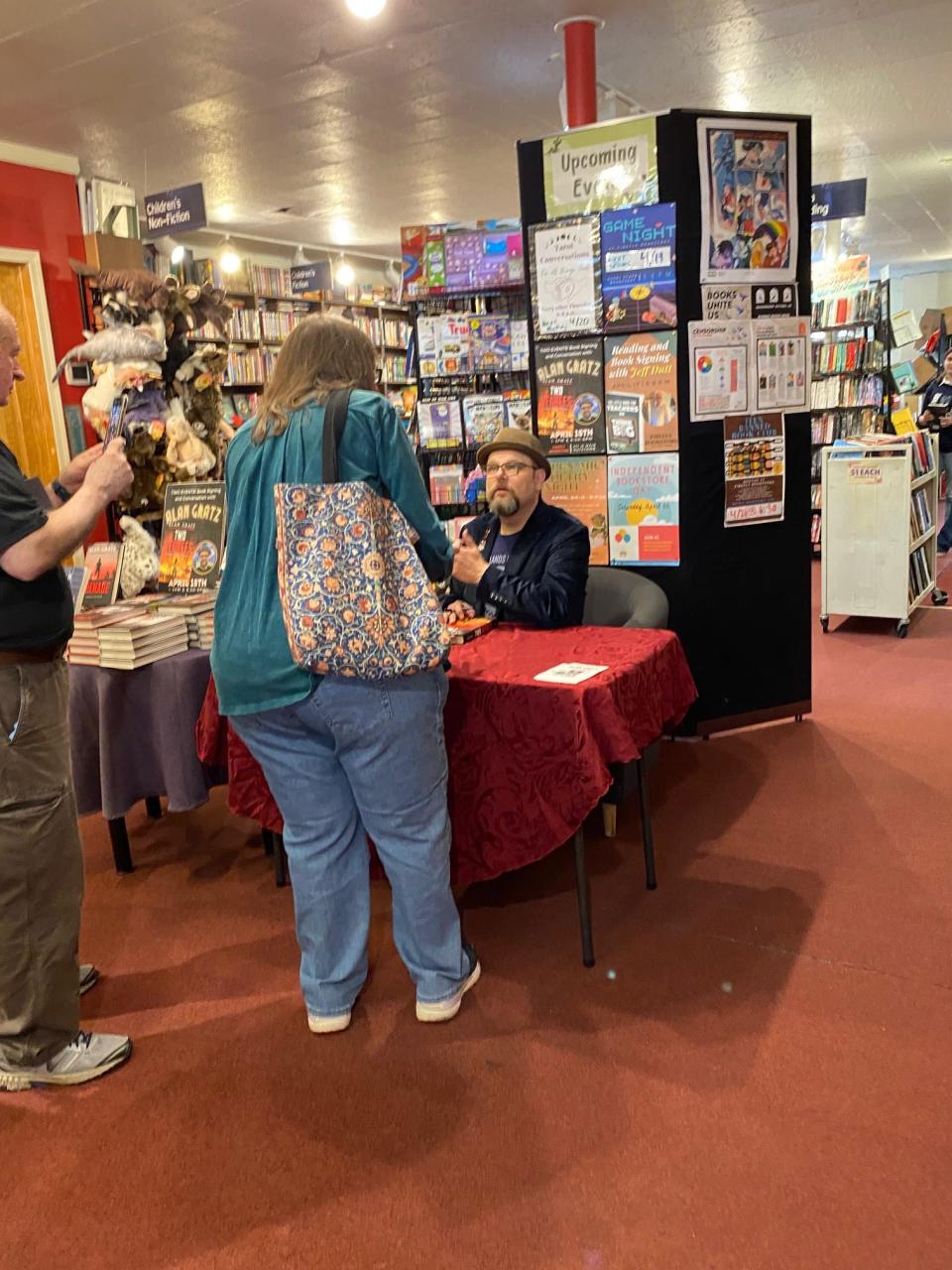 Alan Gratz signs copies of his novel "Two Degrees" at the Firefly Bookstore in Kutztown on April 15, 2023. The local Teen Banned Book Club helped organize a book drive and Gratz's visit after a supplemental middle school reading program featuring his novel was canceled following parents' complaints.