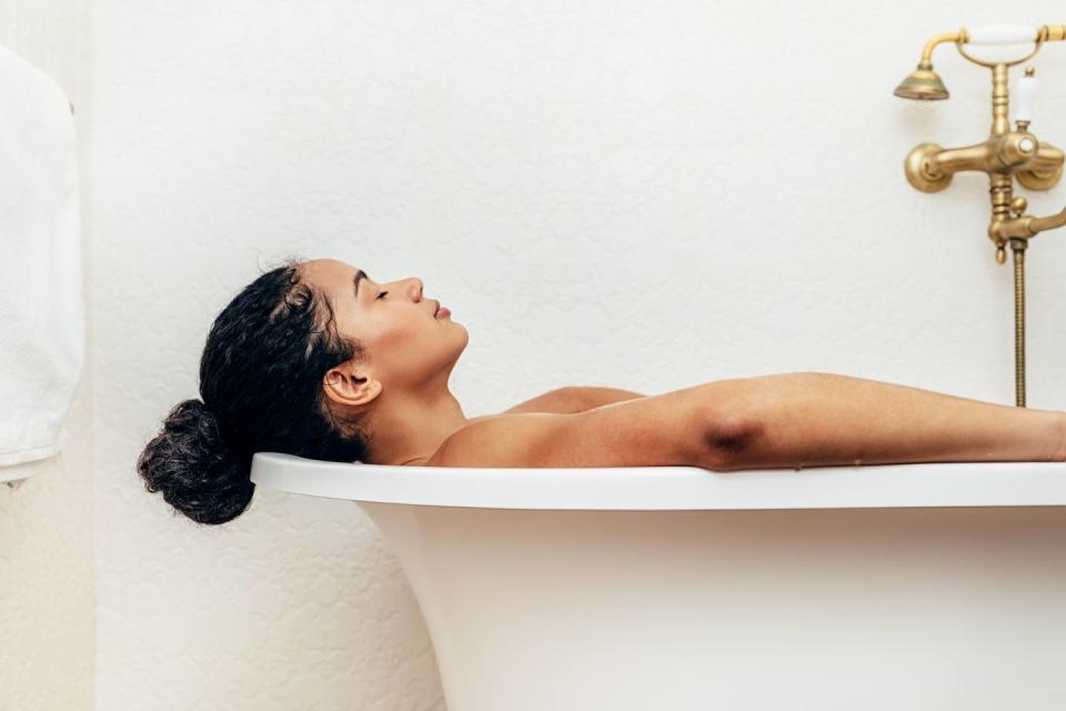 side view of young woman having a bath