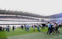 Manchester City's supporters celebrate on the pitch after their team's 3-2 victory over Queens Park Rangers in the English Premier League football match between Manchester City and Queens Park Rangers at The Etihad stadium in Manchester, north-west England on May 13, 2012. Manchester City won the game 3-2 to secure their first title since 1968. This is the first time that the Premier league title has been decided on goal-difference, Manchester City and Manchester United both finishing on 89 points. AFP PHOTO/PAUL ELLIS RESTRICTED TO EDITORIAL USE. No use with unauthorized audio, video, data, fixture lists, club/league logos or 'live' services. Online in-match use limited to 45 images, no video emulation. No use in betting, games or single club/league/player publications.PAUL ELLIS/AFP/GettyImages