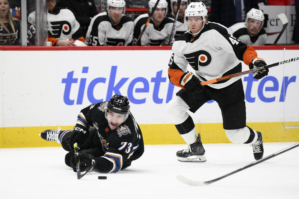 Washington Capitals left wing Conor Sheary (73) and Philadelphia Flyers defenseman Cam York (45) compete for the puck during the first period of an NHL hockey game Saturday, Jan. 14, 2023, in Washington. (AP Photo/Nick Wass)