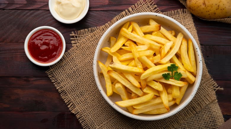 bowl of french fries with condiments