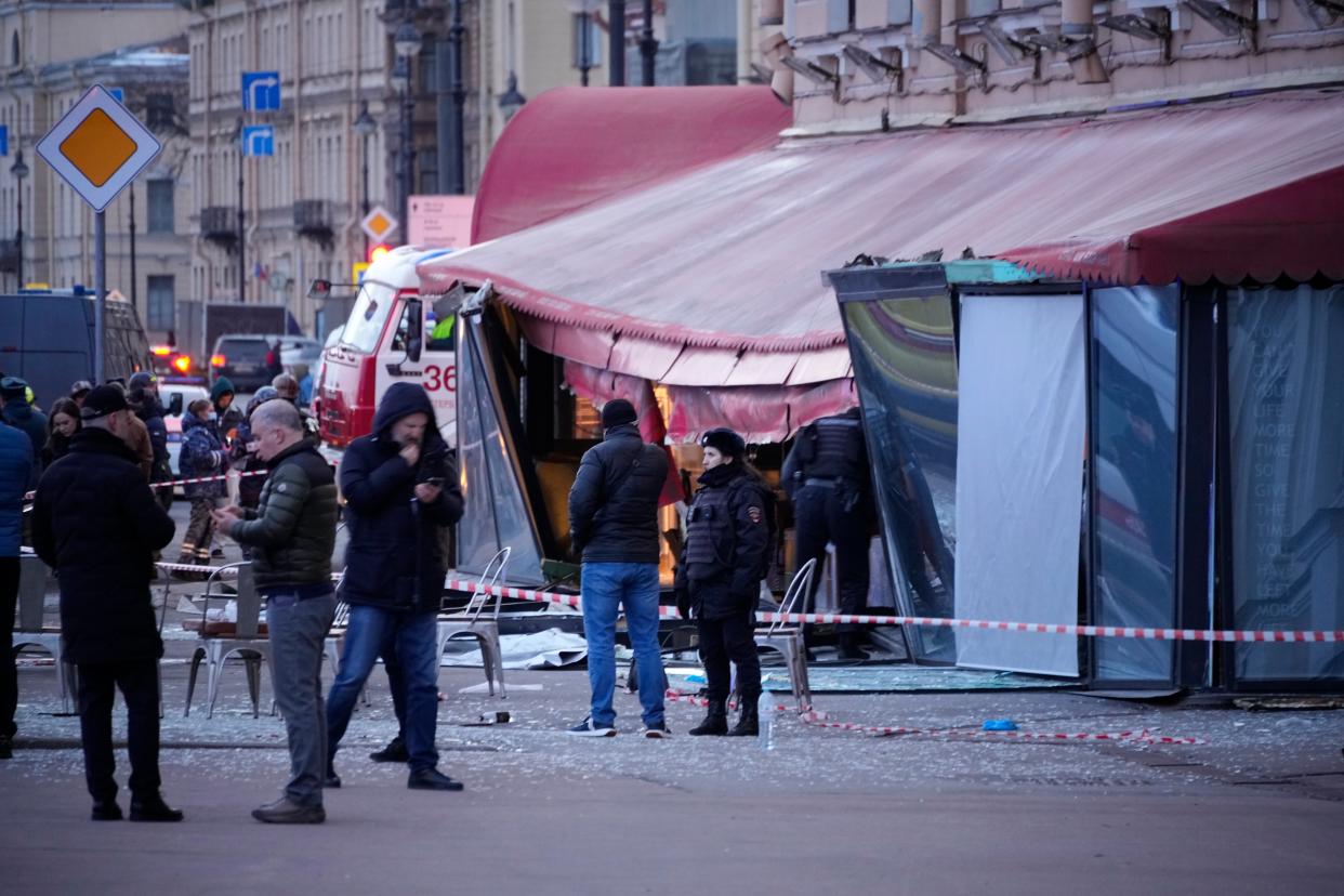 Russian investigators and police officers stand at the side of an explosion at a cafe in St. Petersburg, Russia (AP)