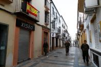 Spanish legionnaires patrol an empty street in downtown Ronda