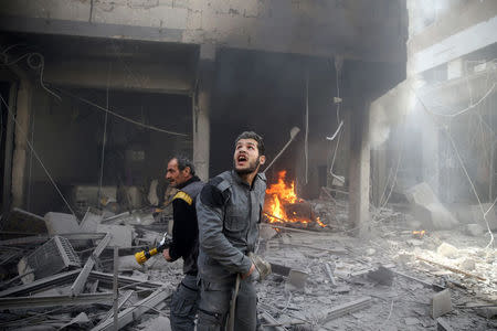 A Civil defence member reacts at a damaged site after an airstrike in the besieged town of Douma, Eastern Ghouta, Damascus, Syria February 9, 2018. REUTERS/Bassam Khabieh