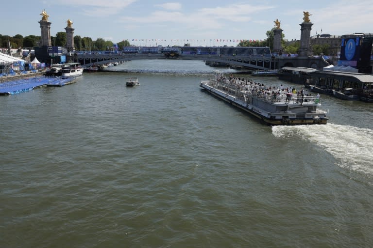 Un barco turístico se acerca al puente de Alejandro III tras la cancelación del primer entrenamiento para el triatlón de los Juegos Olímpicos, el 28 de julio de 2024 en París (Valentine Chapuis)