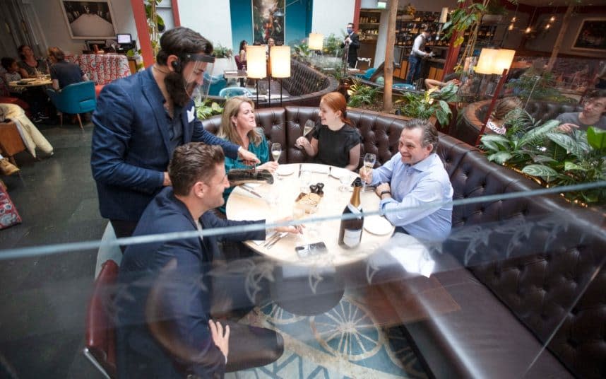 Cheers! A screen separates diners at the Bluebird, in Chelsea. CREDIT: CHRIS GORMAN - CHRIS GORMAN