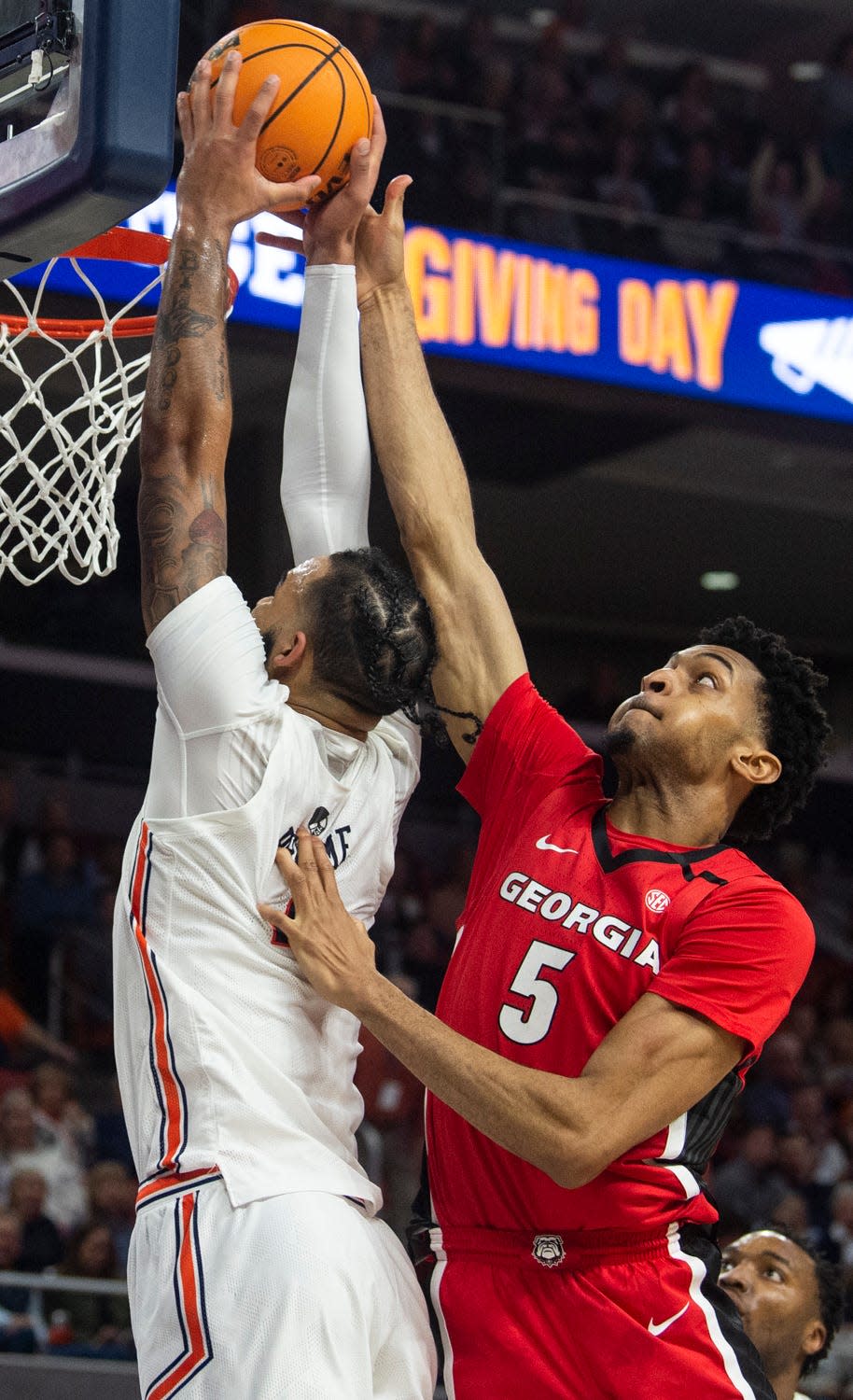 Georgia Bulldogs center Frank Anselem (5) fouls Auburn Tigers forward Johni Broome (4) as he attempts a dunk as Auburn Tigers takes on Georgia Bulldogs at Neville Arena in Auburn, Ala., on Saturday, Feb. 1, 2023. Auburn Tigers lead Georgia Bulldogs 42-24. 