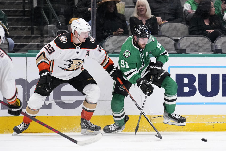 Anaheim Ducks' Jakob Silfverberg (33) and Dallas Stars' Tyler Seguin (91) compete for control of the puck in the second period of an NHL hockey game, Monday, Feb. 6, 2023, in Dallas. (AP Photo/Tony Gutierrez)