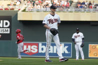 Minnesota Twins pitcher J.A. Happ, center, waits as Los Angeles Angels' Kurt Suzuki, left, rounds the bases on a two-run home run during the first inning of a baseball game, Friday, July 23, 2021, in Minneapolis. (AP Photo/Jim Mone)