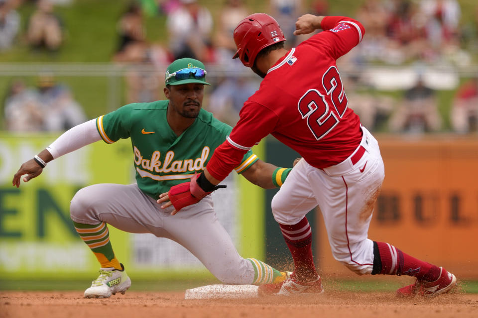 Oakland Athletics' Tony Kemp tags out Los Angeles Angels' David Fletcher (22) on a steal attempt during the third inning of a spring training baseball game, Monday, March 28, 2022, in Tempe, Ariz. (AP Photo/Matt York)