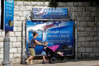 <p>People walk past a banner in support of U.S. President Donald Trump on the day of his visit in Jerusalem on May 22, 2017. (Photo: Menahem Kahana/AFP/Getty Images) </p>