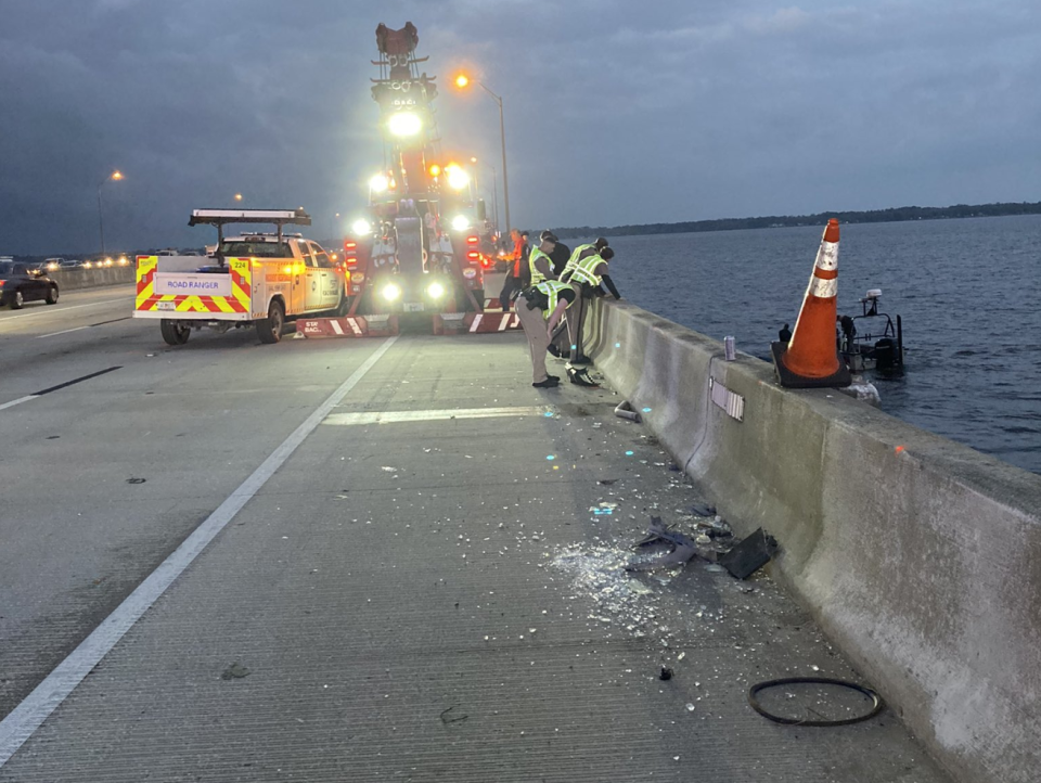 Crews try to reach a submerged car that toppled over the Buckman Bridge after being hit by a Road Ranger truck early Feb. 28, 2023, in Jacksonville.