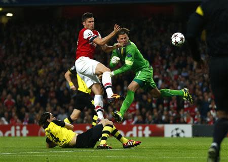 Arsenal's Olivier Giroud (L) challenges Borussia Dortmund's goalkeeper Roman Weidenfeller to score a goal during their Champions League soccer match at the Emirates stadium in London October 22, 2013. REUTERS/Eddie Keogh