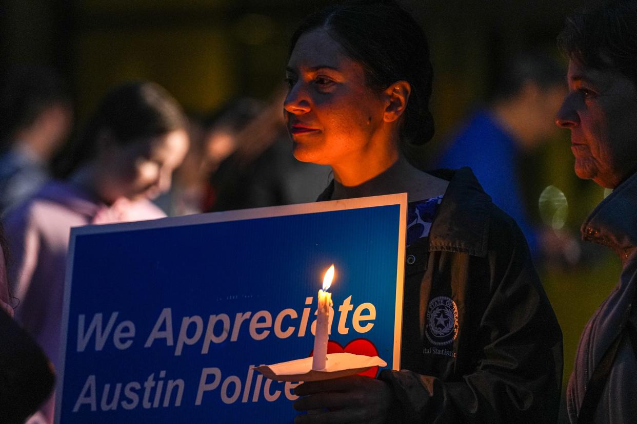 Austin resident Jen D. holds a candle at a rally for the Austin Police Department and candlelight vigil for officer Jorge Pastore at Austin City Hall on Sunday, Nov. 12, 2023. Pastore died after a standoff at a South Austin home where four people died, including Pastore, and two others were injured Saturday, Nov. 11, 2023.