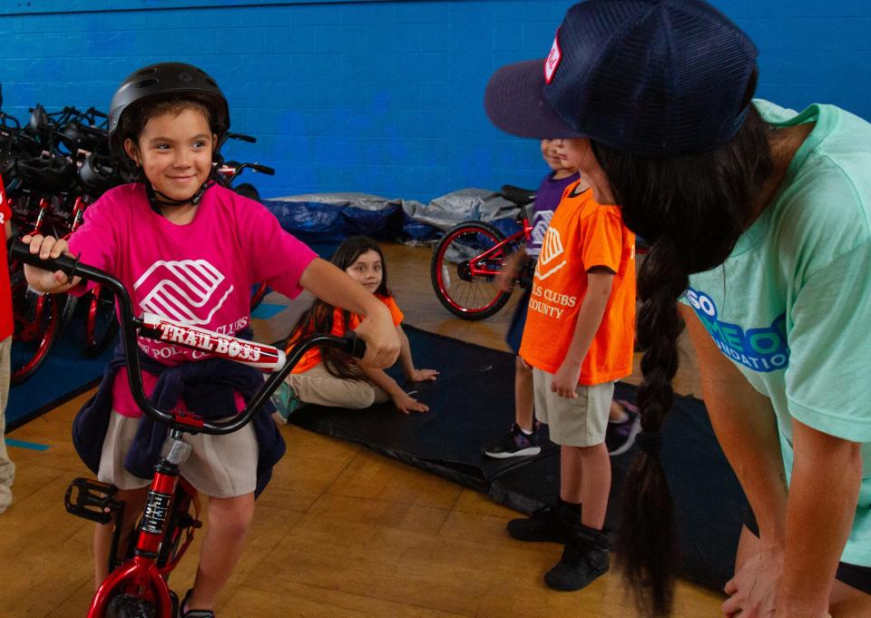 Daneilys Burgos, 8, smiles at Kassi Ackerman, a Can’d Aid employee, after receiving a bike Wednesday afternoon at the Boys and Girls Clubs of Polk County's James J. Musso Unit in Lakeland. Can'd Aid and the Yasso Game On! Foundation gave away 100 bicycles.
