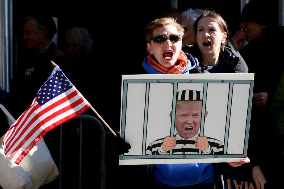 Anti-Trump demonstrators protest outside the Manhattan District Attorney’s office in New York City on Tuesday (AFP via Getty Images)