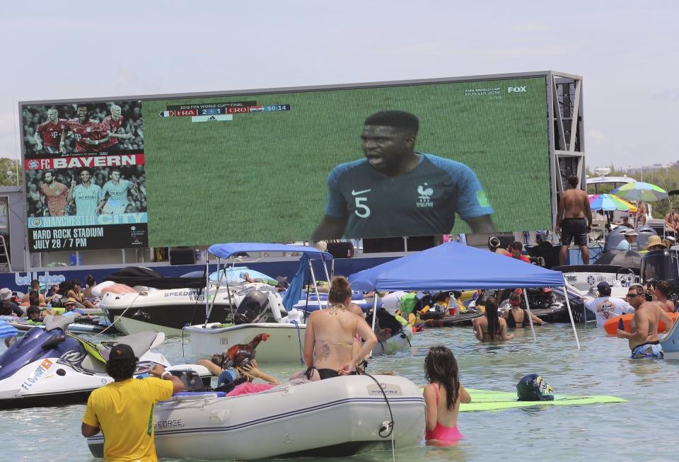 FILE - Soccer fans cool off in the water as they watch a broadcast of France playing Croatia in the World Cup soccer as they attend the "Ballyhoo Boat Bash" at the Haulover Sandbar in Miami, on July 15, 2018. .S. cities and states have lined up with tax breaks and millions of dollars in both public and private investments for a chance at hosting 2026 FIFA World Cup games, set to be announced Thursday, June 16, 2022. (Carle Juste/Miami Herald via AP, File0