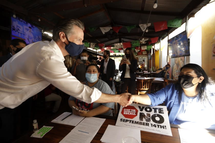 EAST LOS ANGELES, CA - AUGUST 14, 2021 - -California Gov. Gavin Newsom greets volunteers who were working the phone banks in support of voting against the governor's recall at Hecho en Mexico restaurant in East Los Angeles on August 14, 2021. Los Angeles City Councilman Kevin de Leon, California State Senator Maria Elena Durazo, California Assemblyman Miguel Santiago and other Latino dignitaries were on hand to support the governor. (Genaro Molina / Los Angeles Times)