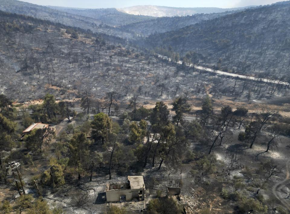 A damaged house is seen in a burnt forrest in Mandra, west of Athens, Greece, on Wednesday, July 19, 2023. Wildfire evacuations have continued for a third day outside the Greek Capital as a second heat wave hit the Mediterranean country from the west after days of record-high temperatures baked southern Europe. (AP Photo/Thanassis Stavrakis)