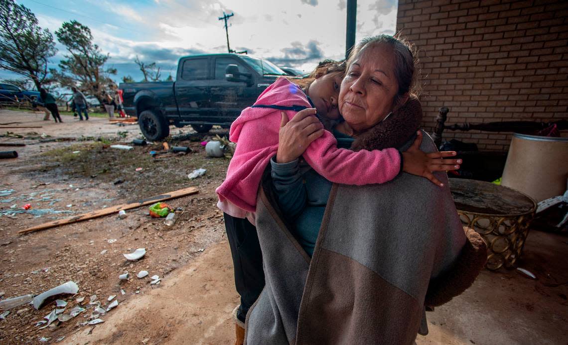 Bertha Gonzalez is comforted by her granddaughter Isa. Both were in the house when the twister hit. A tornado touched down just south of Decatur, Texas, along FM 730 early morning Tuesday, Dec. 13, 2022, tearing the roof off of a home and ripping trees in half. Debris was strewn across the highway.