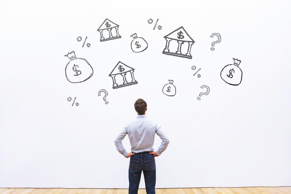 man looking at investment banking icons on wall