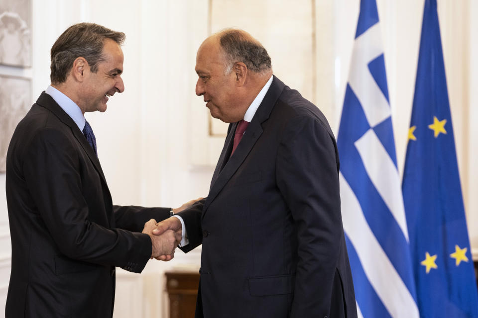 Greek prime minister Kyriakos Mitsotakis, left, welcomes Egyptian Foreign Minister Sameh Shoukry, right, during their meeting in Athens, on Tuesday, April 11, 2023. Greece and Egypt have close military ties and are planning to build an undersea electricity grid connector across the Mediterranean. (AP Photo/Petros Giannakouris)